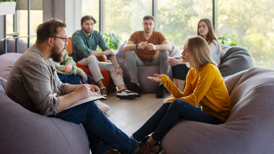 Gruppe junger Menschen diskutiert in gemütlicher Runde auf Sitzsäcken als Symbolbild für Fokusgruppe in der Marktforschung