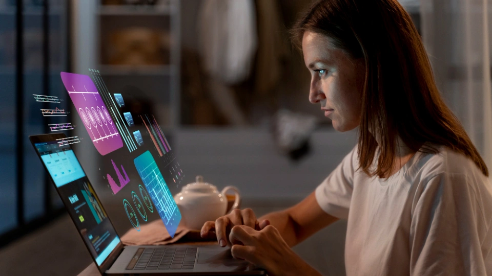 Frau arbeitet nachts konzentriert am Laptop mit futuristisch dargestellten KI-Datenvisualisierungen