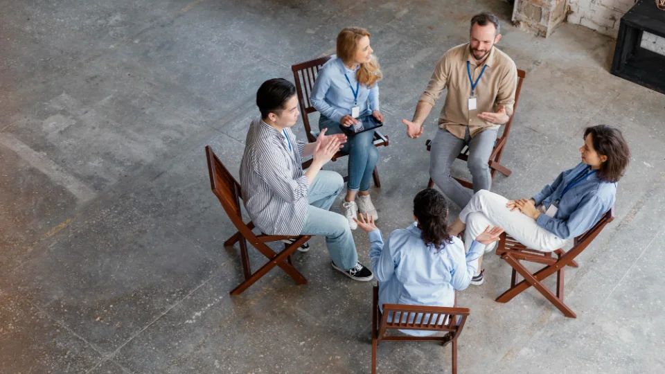 Fünf Personen mit Namensschildern sitzen im Stuhlkreis und diskutieren in einer Fokusgruppe von oben fotografiert